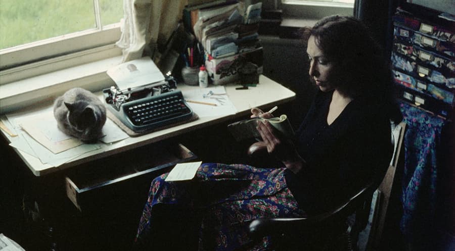 Woman sitting at her desk writing in a notebook.