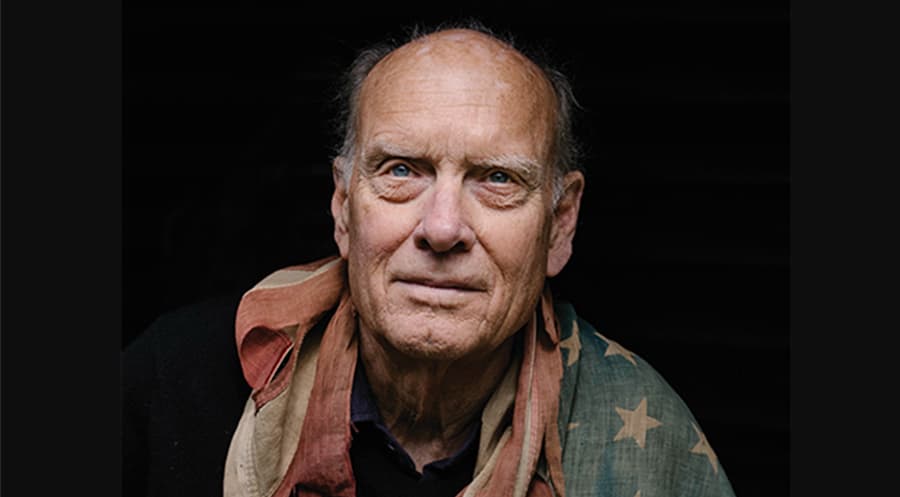 Photograph of a man draped in the American flag.